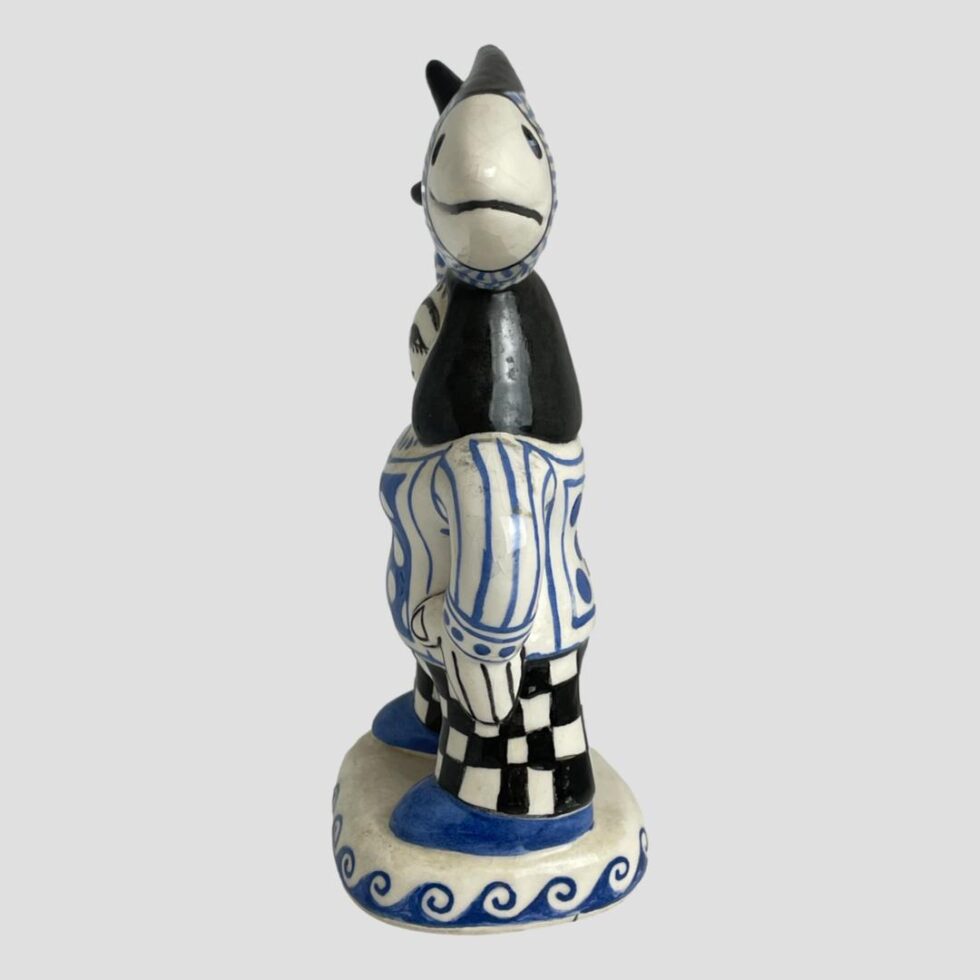 The fisherwoman is now facing direct left with the fish facing straight at camera.