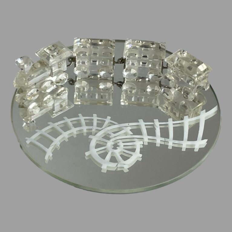 Main photo of Swarovski crystal train set displayed on the round mirror. The train and carriages are at the top of the round mirror while the white rail track which has a loop in it is seen below. The train engine is on the left with the 3 carriages attached via metal hooks and each piece is expertly crafted. A fabulous gift for the train enthusiast, Swarovski collector or 15th wedding anniversary (or anyone who loves pretty things!)