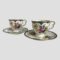 Main photo of pair Cauldon cups &saucers displayed side by side with cups on their saucers. The cups are small so ideally suit espresso coffees or specialist teas. Each cup and saucer is beautifully decorated with vibrant flowers in different bright colours with a lovely butterfly on the saucer dip and inside of cup.