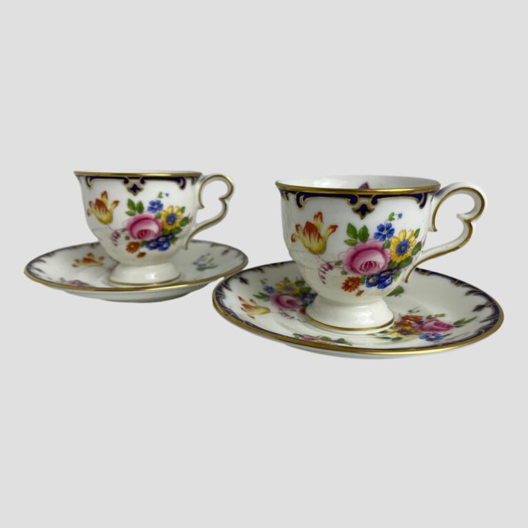 Main photo of pair Cauldon cups &saucers displayed side by side with cups on their saucers. The cups are small so ideally suit espresso coffees or specialist teas. Each cup and saucer is beautifully decorated with vibrant flowers in different bright colours with a lovely butterfly on the saucer dip and inside of cup.