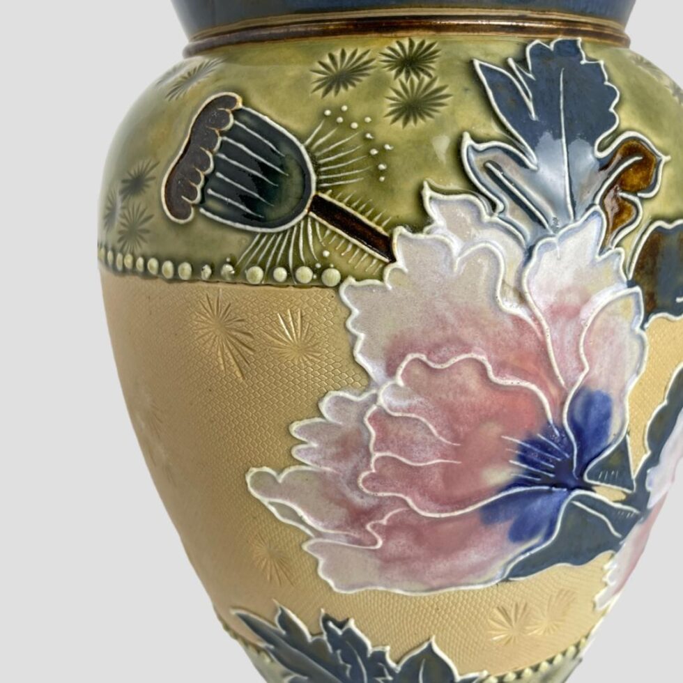 Close up photo of the last poppy along - this one is seen from a side angle so only the petals are visible. There is a seed capsule above and to the left of this poppy which is also in a dark teal blue.