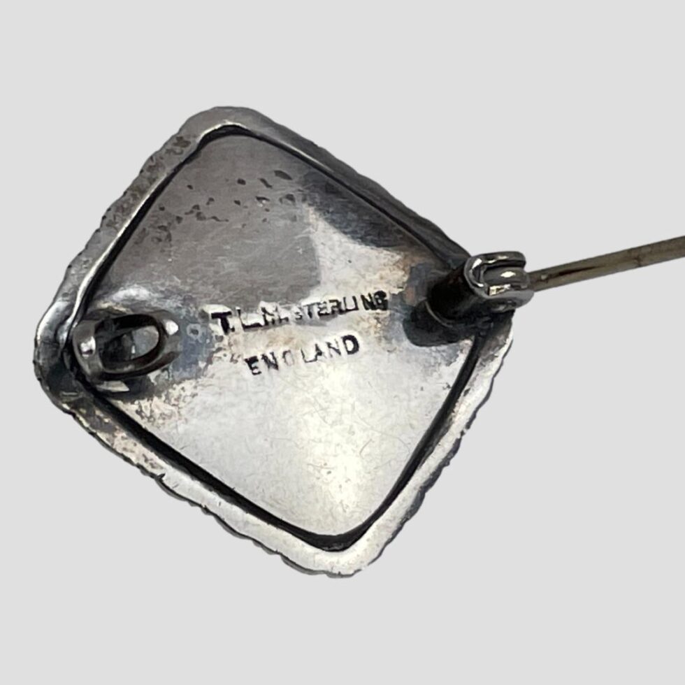 Photo of back of brooch with pin open and revealing the mark T.L.M STERLING ENGLAND