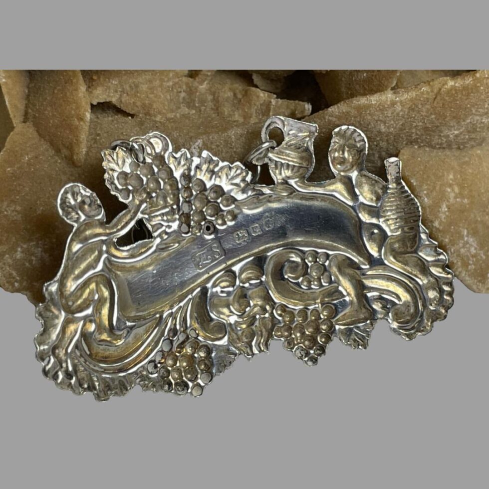 Photo of the back of the silver whisky decanter label. The hallmark is visible to the back of banner area.