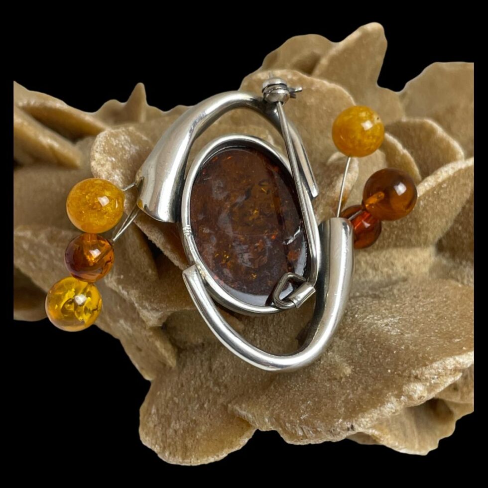 Photo of the back of sterling silver amber brooch showing the frame work of the brooch design.