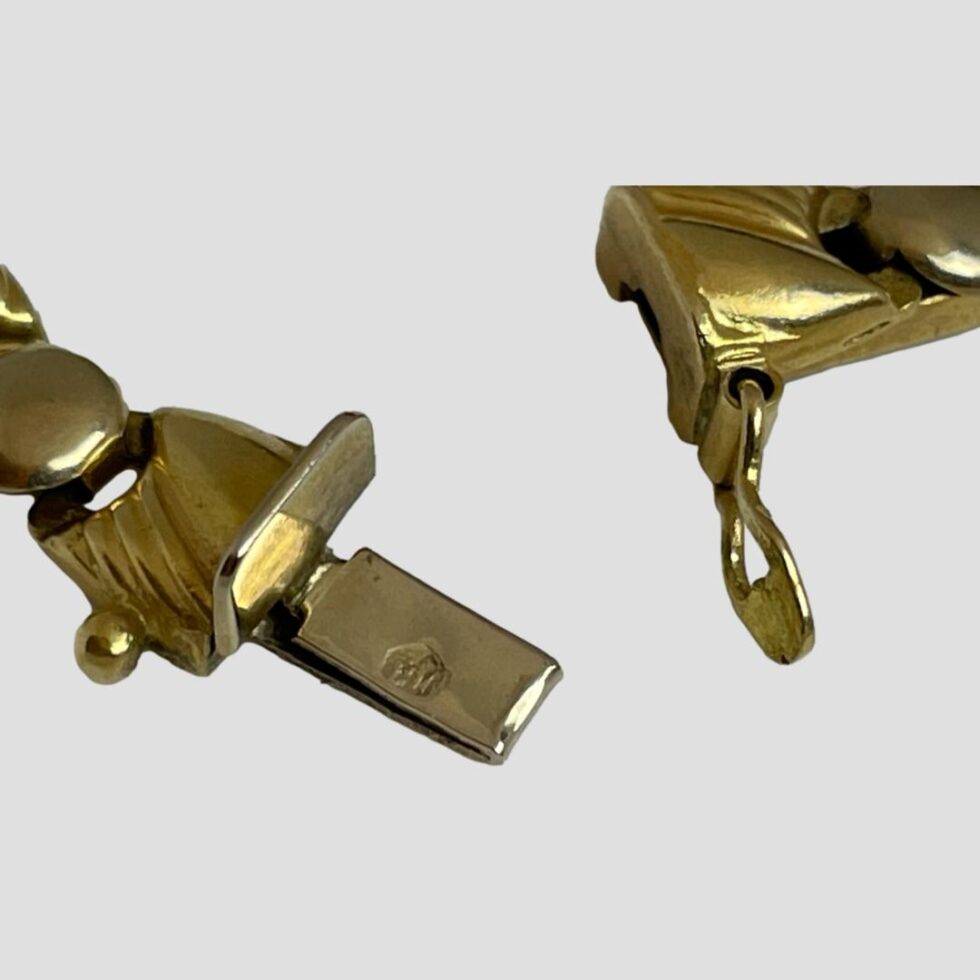Close up photo of the clasp area with the clasp shown undone. One of the hallmarks is visible to the clasp end on the left.