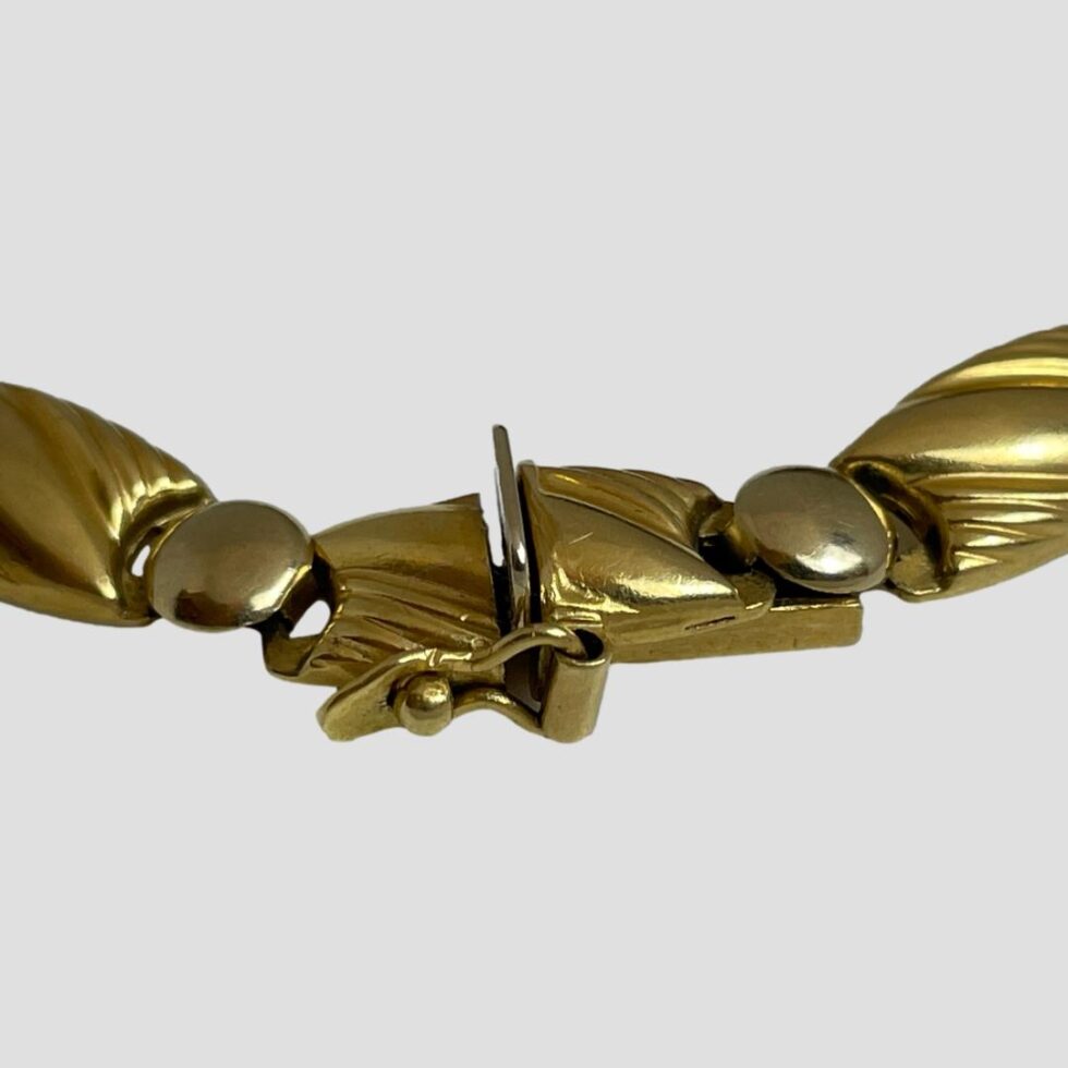 A close up of the clasp area of the Egyptian gold bracelet showing the clasp and security clip closed.