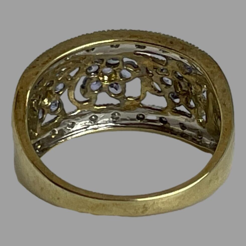 Photo of the back of modern gold tanzanite ring with ring front facing away from shot showing the back of the stone setting.