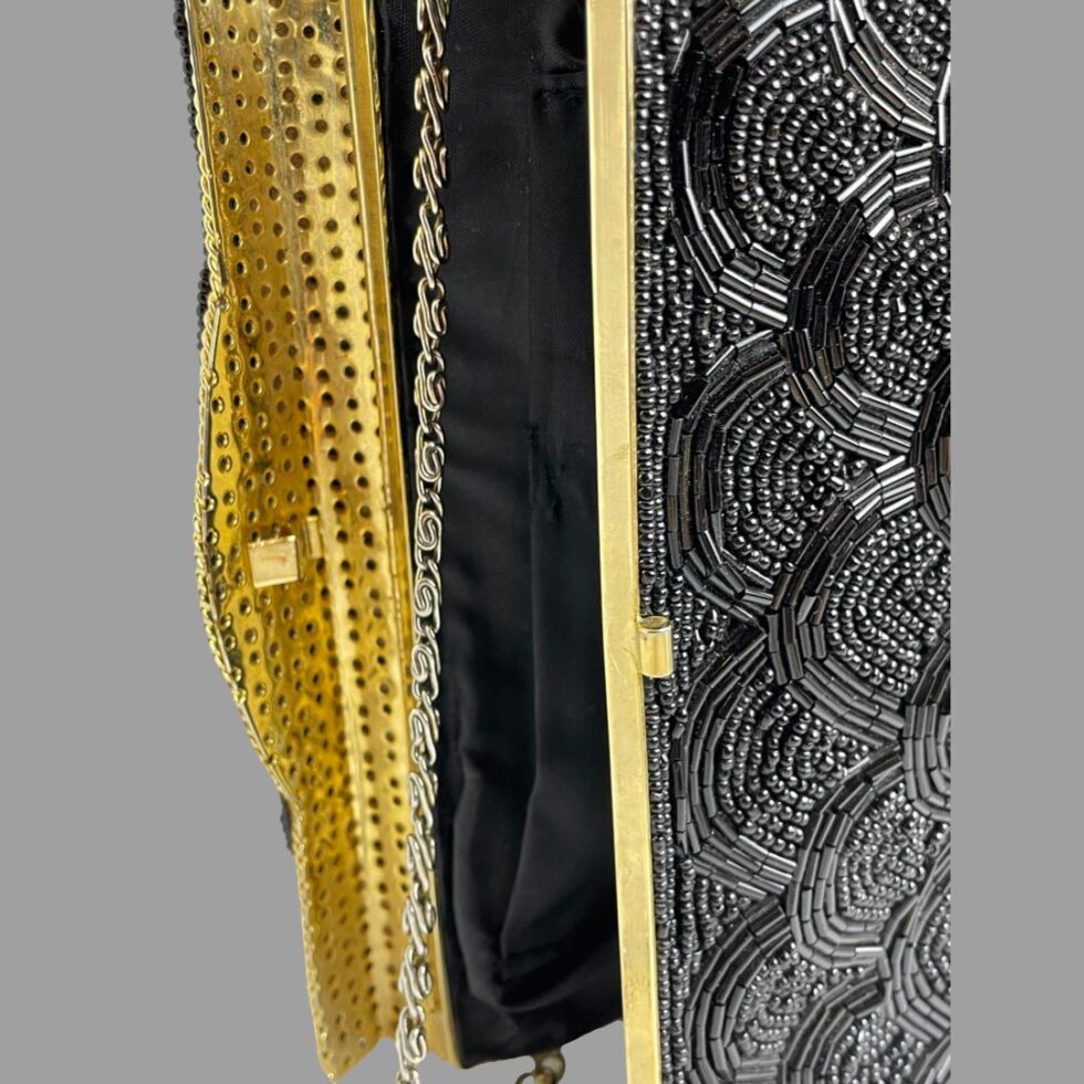 A close up photo of the bag opening showing the closing catch and the metal flap.