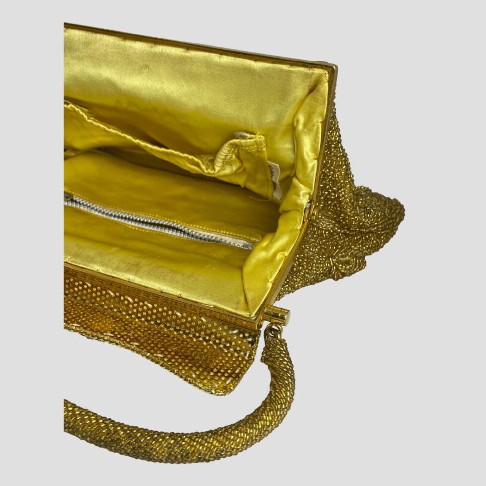 A close up photo of one end of the open gold beaded bag.