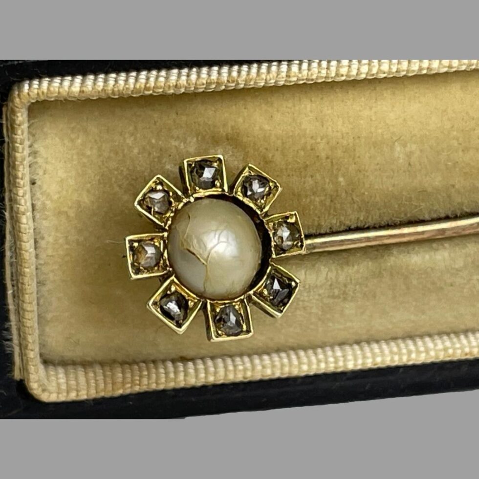 Close up photo of the flowerhead. The old rose cut diamonds are giving a lovely sparkle and distracting from the crack in the pearl.