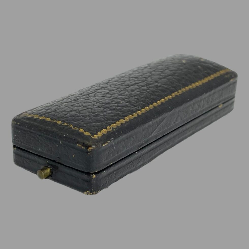 Photo showing the original case housing the Victorian stick pin which is shown closed. There are some minor signs of wear otherwise very good for its age.