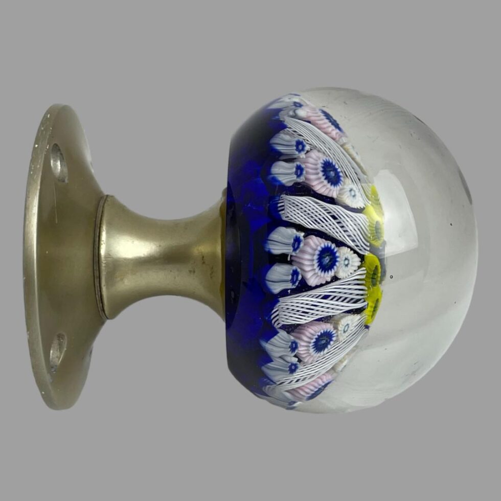 Photo of Strathearn glass door knob seen from a direct side view with the domed glass end on the right and the brass coloured metal fixing to the left.