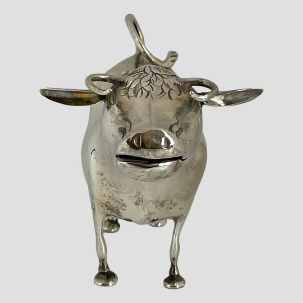 Photo of silver cow creamer seen from the front with the cow looking straight to camera. The ears are sticking out to the sides.
