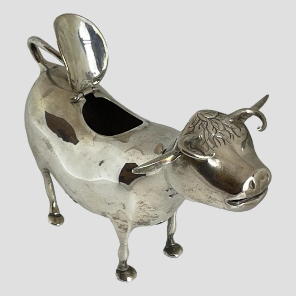 Photo of cow this time looking to the bottom right corner. The hinged flap on its back is shown open.