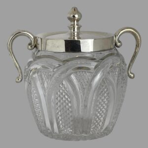 Main photo of glass &silver biscuit barrel seen from an eye level with the handles on left and right. The cut glass base is finely detailed which compliments that plain silver to the top. The silver handles have a upward loop with the ends hanging down to around the most bulbous part of the barrel. They are attached to the silver rim around the mouth. The lid also in silver has a fairly tall finial for easy removal. A lovely piece of late Victorian early Edwardian tableware.