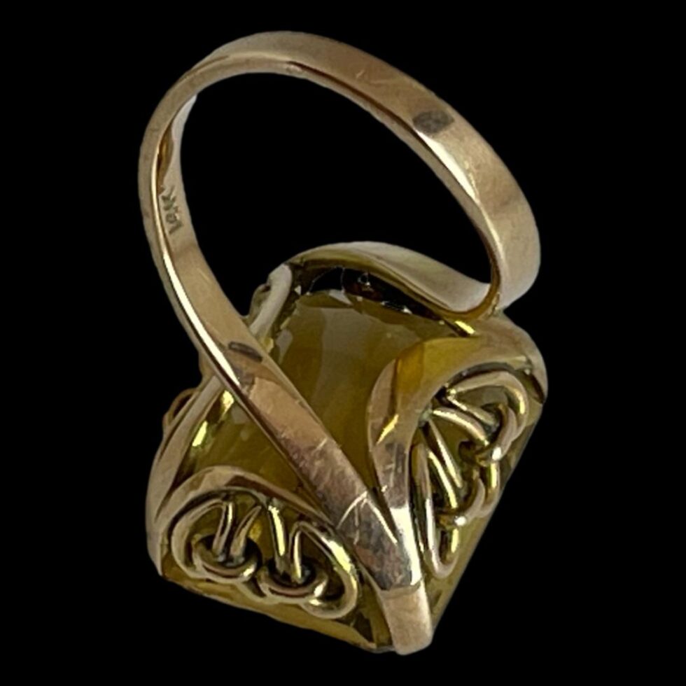 Photo of large faceted citrine ring laid face down to clearly show the band design and stone setting.