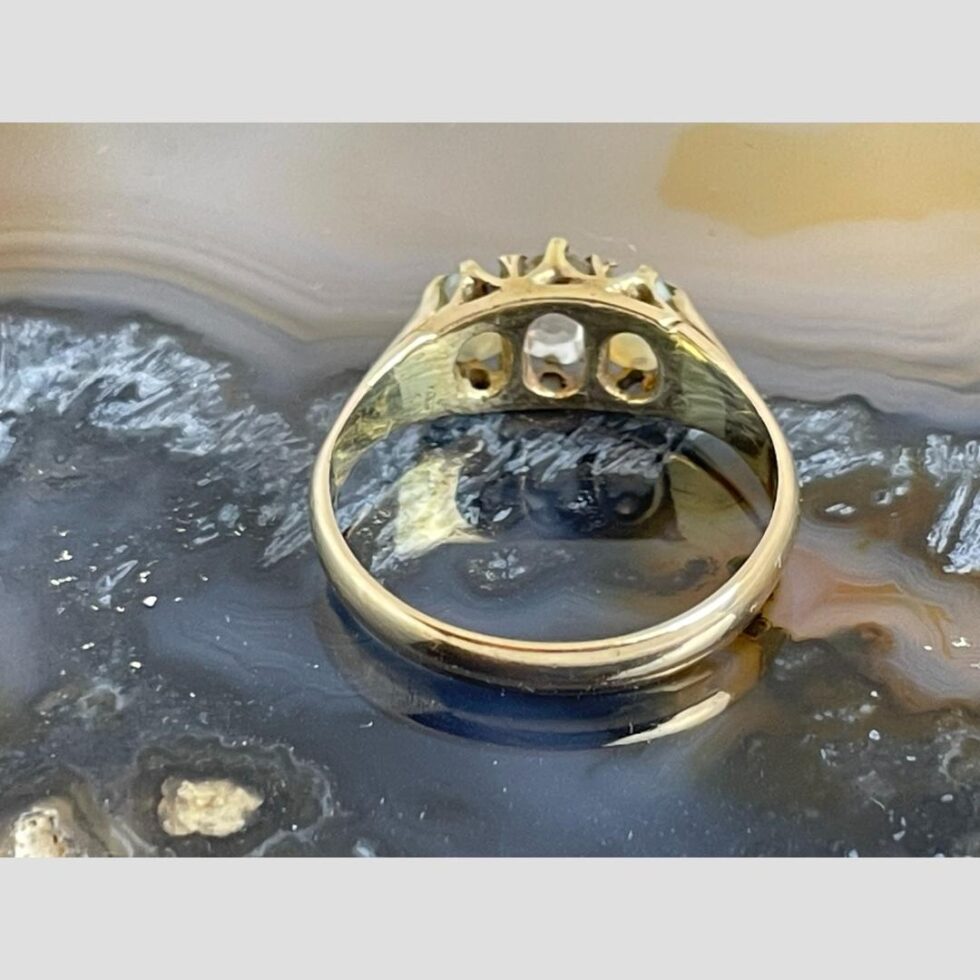 Photo of ring displayed on the slice of agate this time shown from the back with the gem stones setting visible.