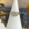 Main photo of Victorian opals &diamond ring displayed on a white cone shaped stand with a slice of natural agate behind it. The old cut oval diamond although larger than the opals appear to pale in comparison with the colourful opals stealing the show here. In certain light it will be a whole other story! The stones are all held in place with 'teeth'.