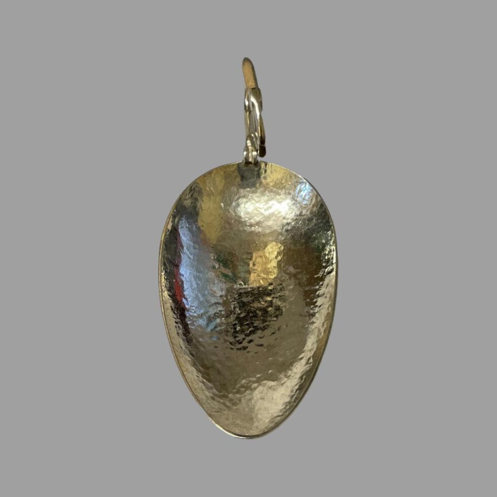 Photo looking straight down into the spoon bowl. The swan head handle is at the centre top. Somewhere in the hammered silver bowl are the initials.