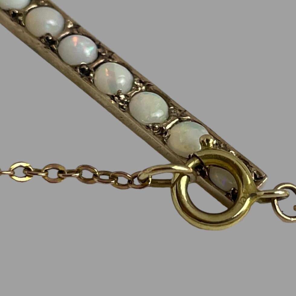 Close up photo of the 0ct hallmark on the clasp of the chain with some of the opals visible behind.
