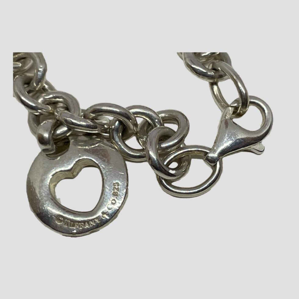 Close up photo of the clasp area and the heart charm which has the Tiffany & Co stamp and hallmark. The clasp is shown closed with the 925 hallmark just visible.