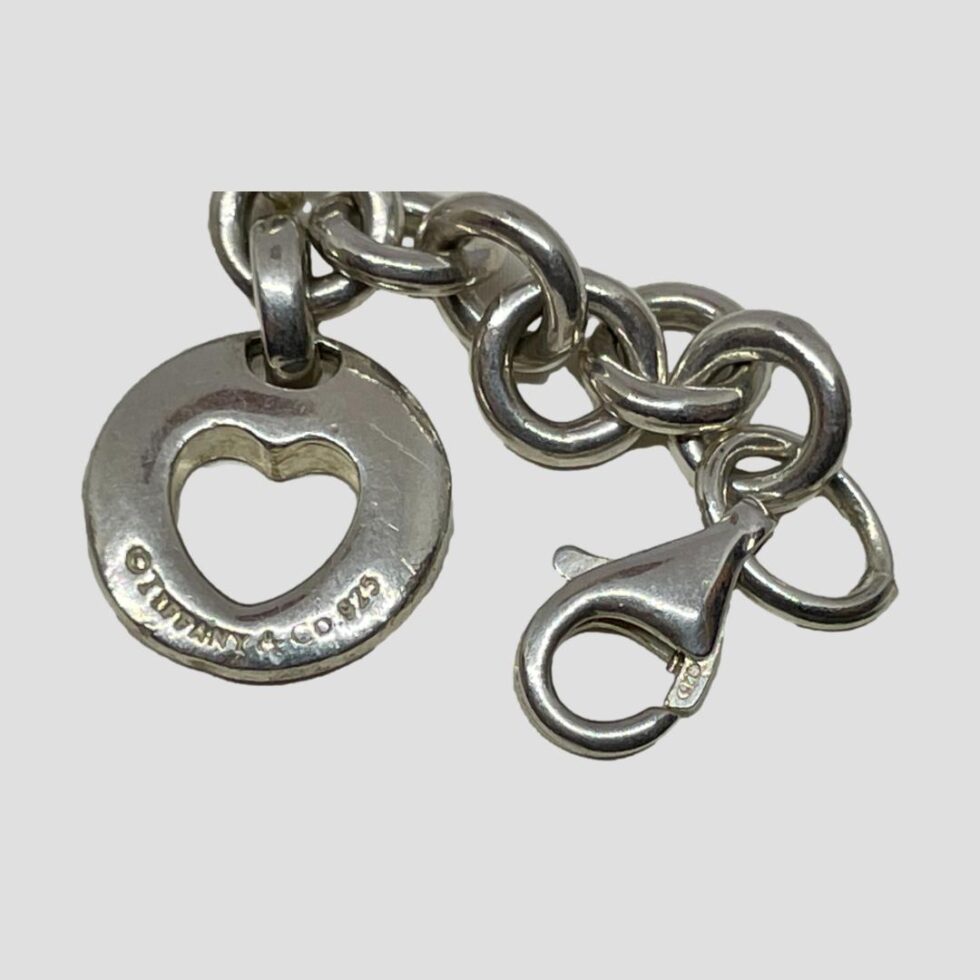 Another photo of the clasp area of the Tiffany &Co charm bracelet. This time the clasp is shown as undone and the hallmark on the heart charm and clasp are visible.