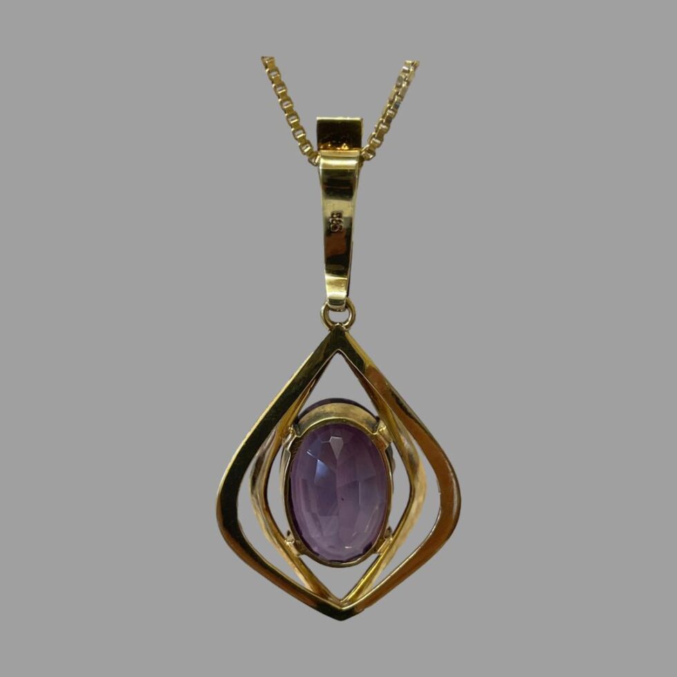 Photo of the back of amethyst pendant showing the hallmark to the back of the bail and the frame setting for the amethyst stone.