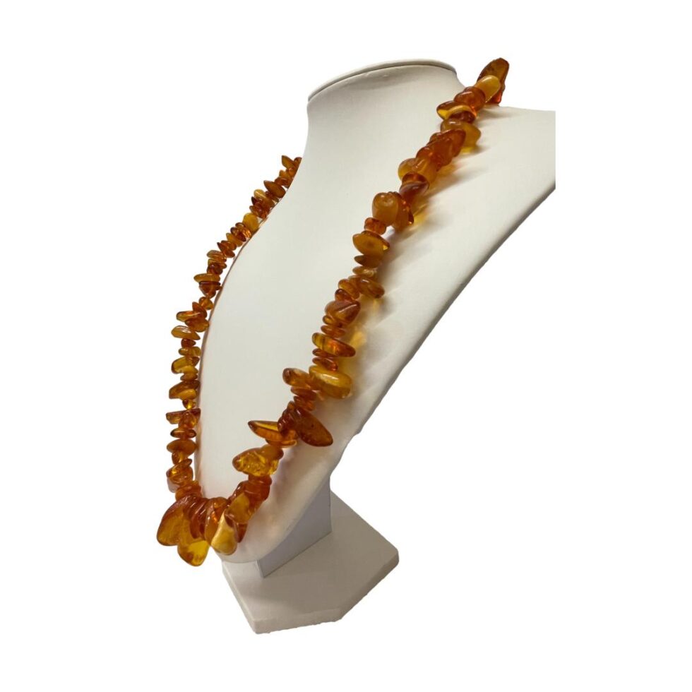 Photo of vintage Baltic amber necklace still displayed on a stand this time with the front of necklace facing towards the left.