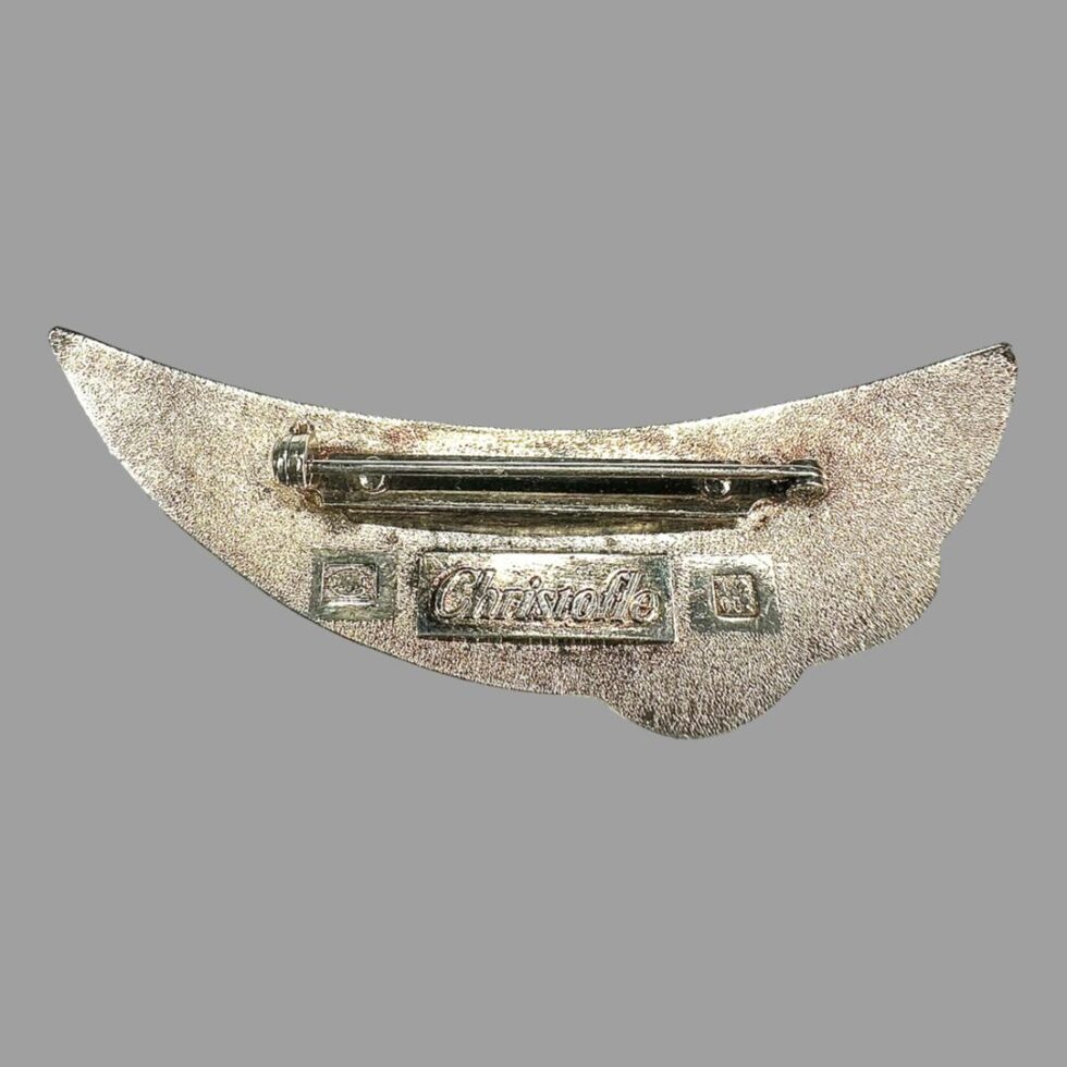 Photo of the back of Christofle silver plate brooch displayed the same way up to main photo. The pin is across the top at the centre of the widest area and the Christofle stamp and marks are below.