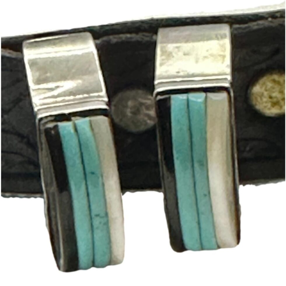 Close up photo of the 2 belt loops which are inlaid with turquoise, mother-of-pearl and black onyx.