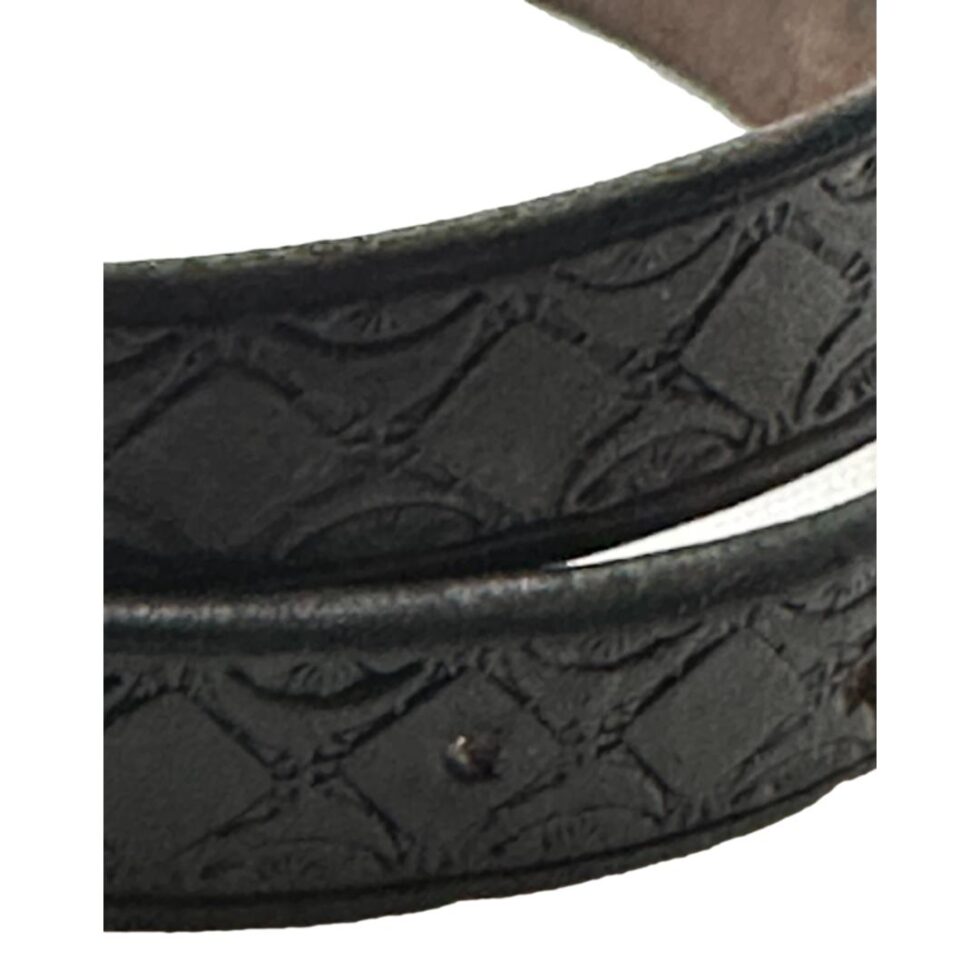 Close up photo of the tooled black leather belt.