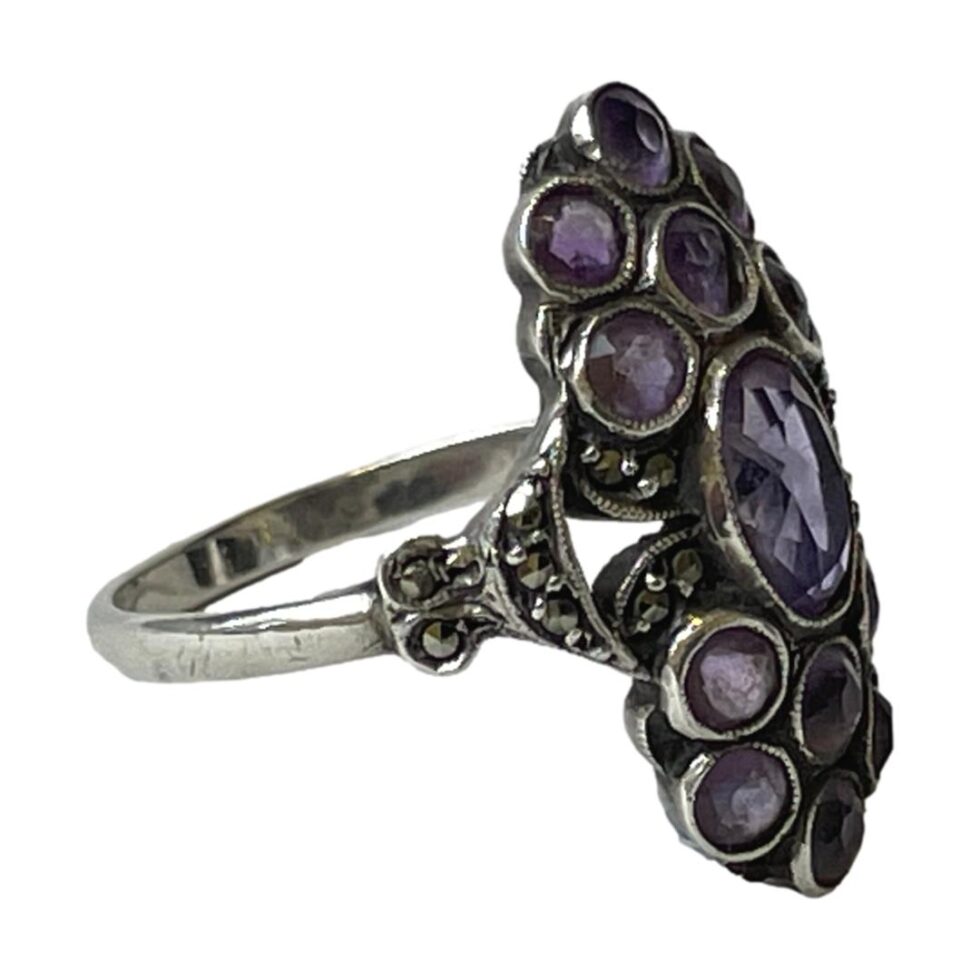 Photo of 935 silver amethyst ring displayed on a flat surface with ring front facing right and showing the shoulder with marcasite.