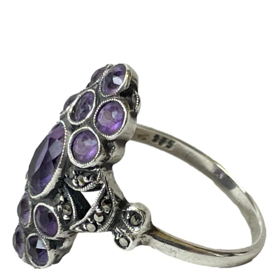 Photo of ring on a flat surface and this time facing left. The hallmark is just visible to inside band.