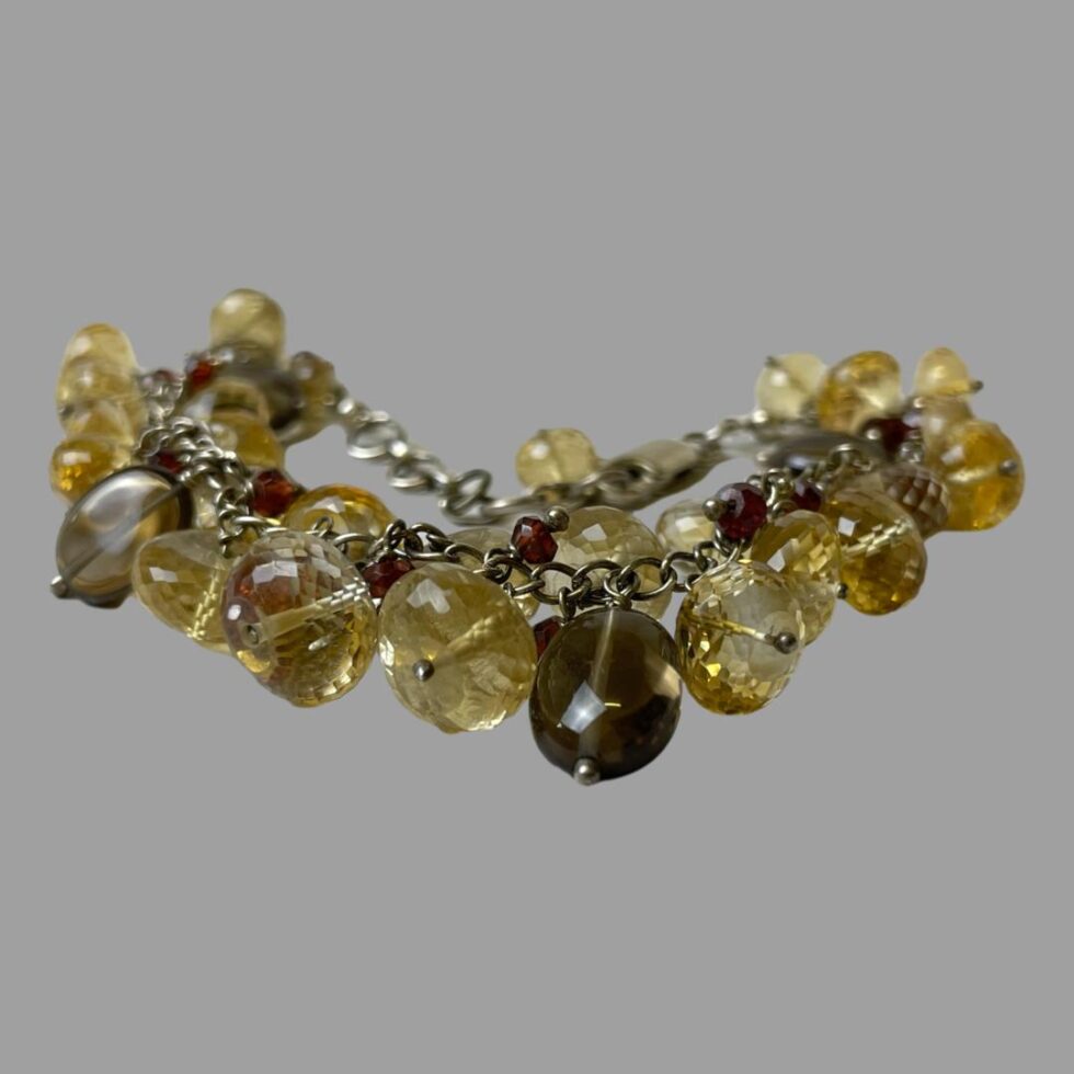 Photo of silver quartz crystal bracelet seen from an almost eye level with some of the multiple quartz crystal beads in the foreground.