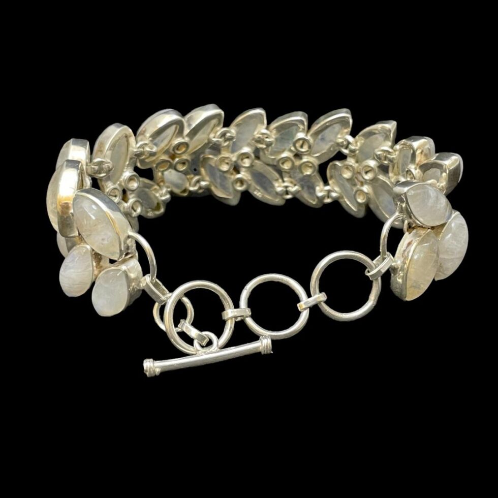 Photo of bracelet displayed with clasp closed and bracelet laid in an upright circle. The clasp area is in the foreground and has 3 rings and toggle. in the background the incredible silver workmanship can be seen as well as the 925 hallmark on the lower middle stone backing.