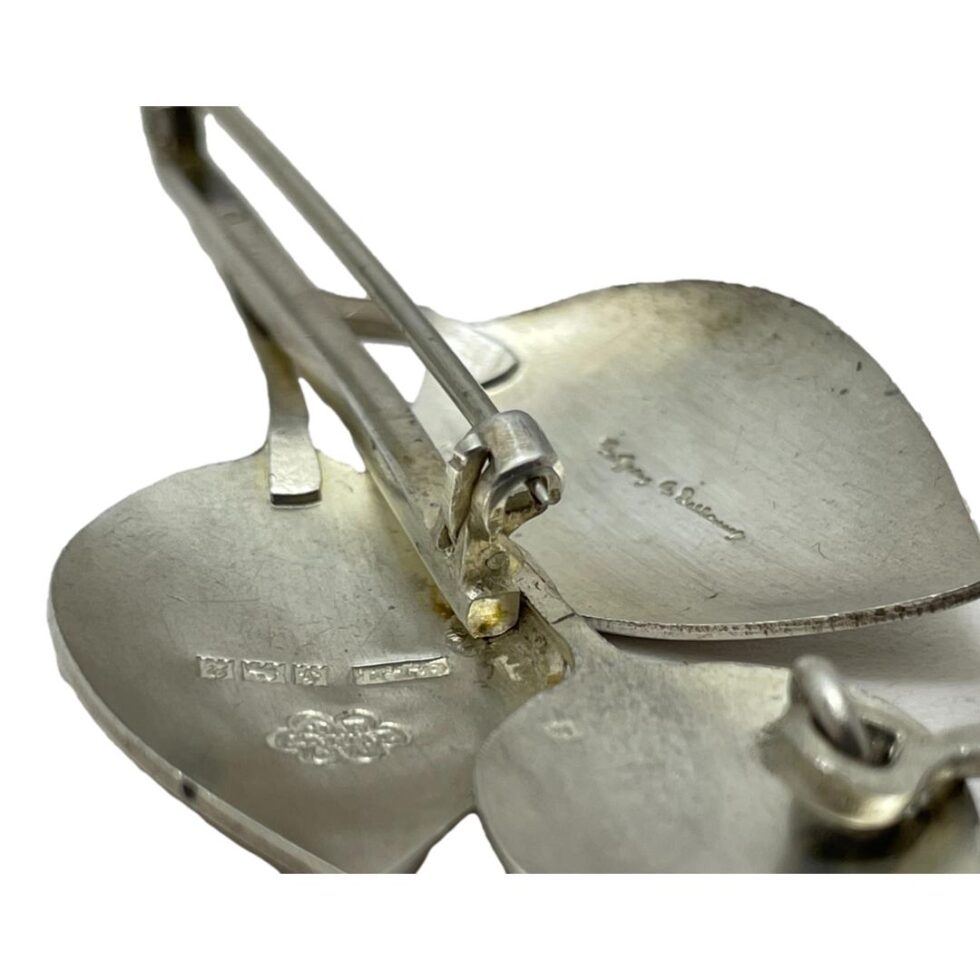 Close up- photo of the clasp area seen from pin end showing the pin positioned in place and 'click to shut' clasp clicked shut.