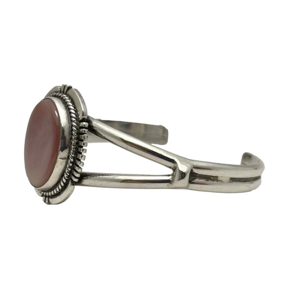 Photo of cuff bracelet displayed from a side angle with the shell front on the left. The split band shoulder design is clearly seen here.