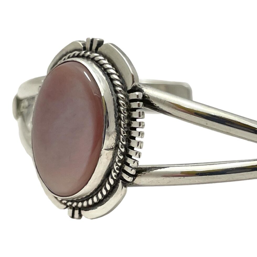 A close up photo of the shell area of the signed Navajo cuff bracelet. The shell area is facing the bottom left of the photo.