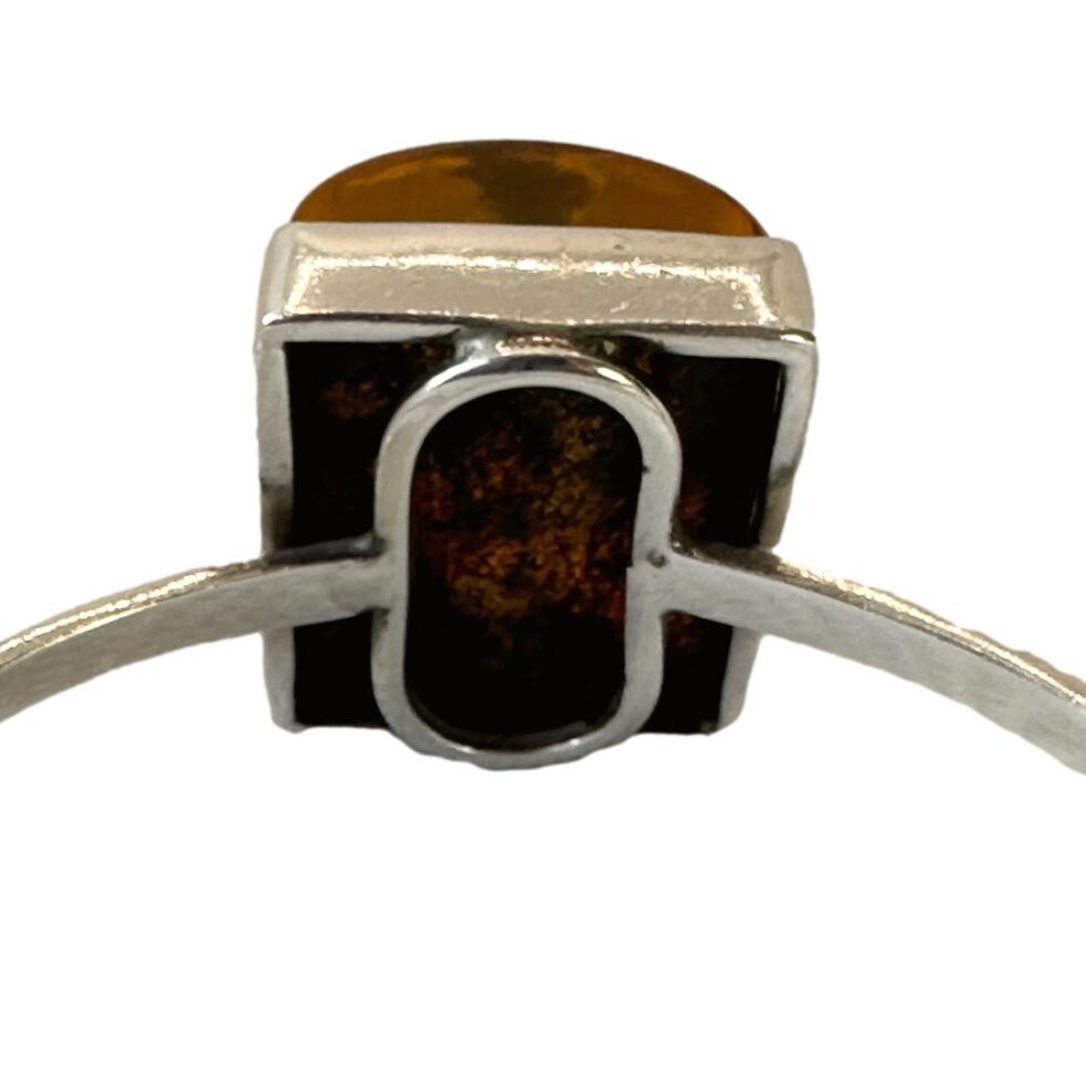 Photo of the back of the amber setting showing the silver framework holding the amber in place.