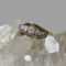 Main photo of gold platinum diamond ring displayed on top of a rock of natural quartz crystal and seen with ring front facing forward. The gold band is split with each end curved over the diamonds which are set in platinum at the centre. The ring is displayed on top of a rock of natural quartz crystal.