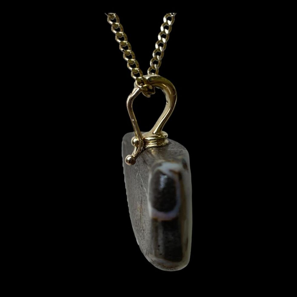 Photo of boulder opal pendant in close up seen this time still hanging and from a side angle to show the depth of the opal stone and the clip open design of the bail.