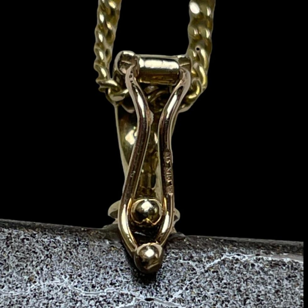 Close up photo of hallmark on the pendant bail at back.