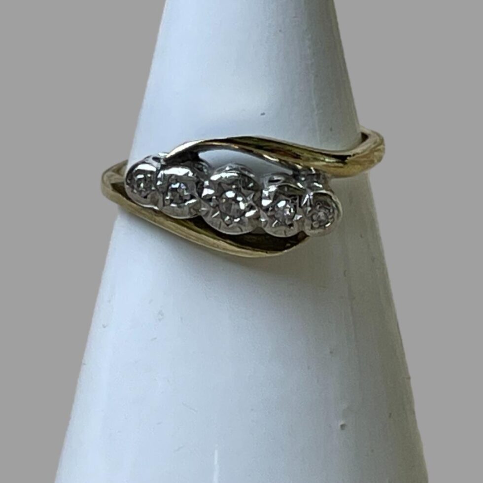Photo of gold platinum diamond ring displayed on a cone shaped display stand with the ring front forward facing.