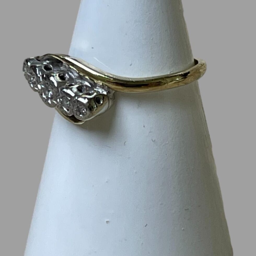 Photo of ring still displayed on a cone shaped stand with the ring front facing towards left.