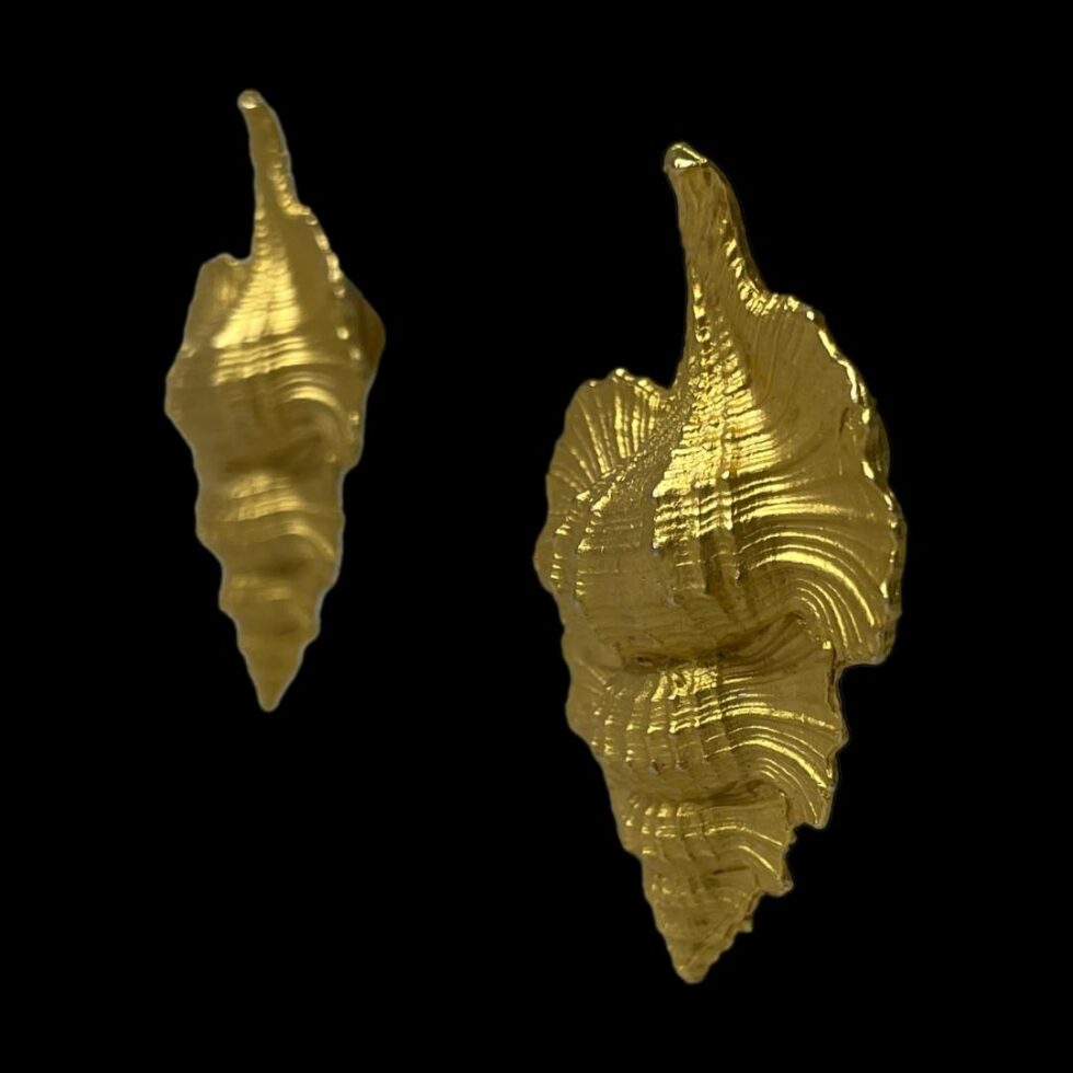 Photo of both designer shell clip-ons seen from a slight side view with the fronts facing to the bottom left corner. to show the depth.