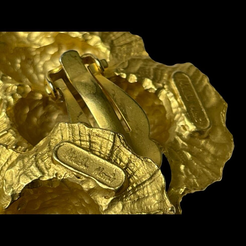 Close up photo of the designers stamp on the back of one of the earrings.