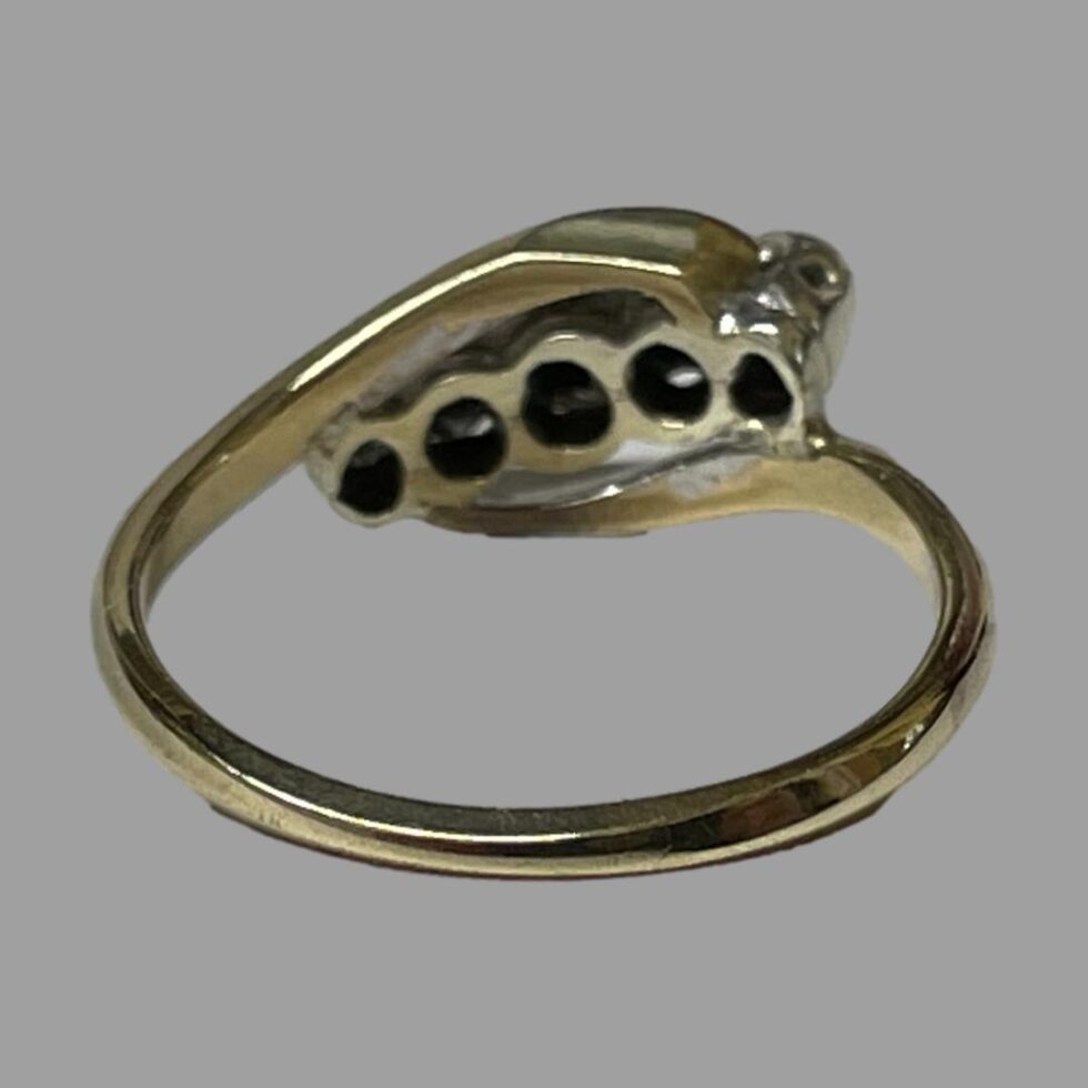 Photo of gold platinum diamond ring seen from the back showing the platinum setting for the diamonds.