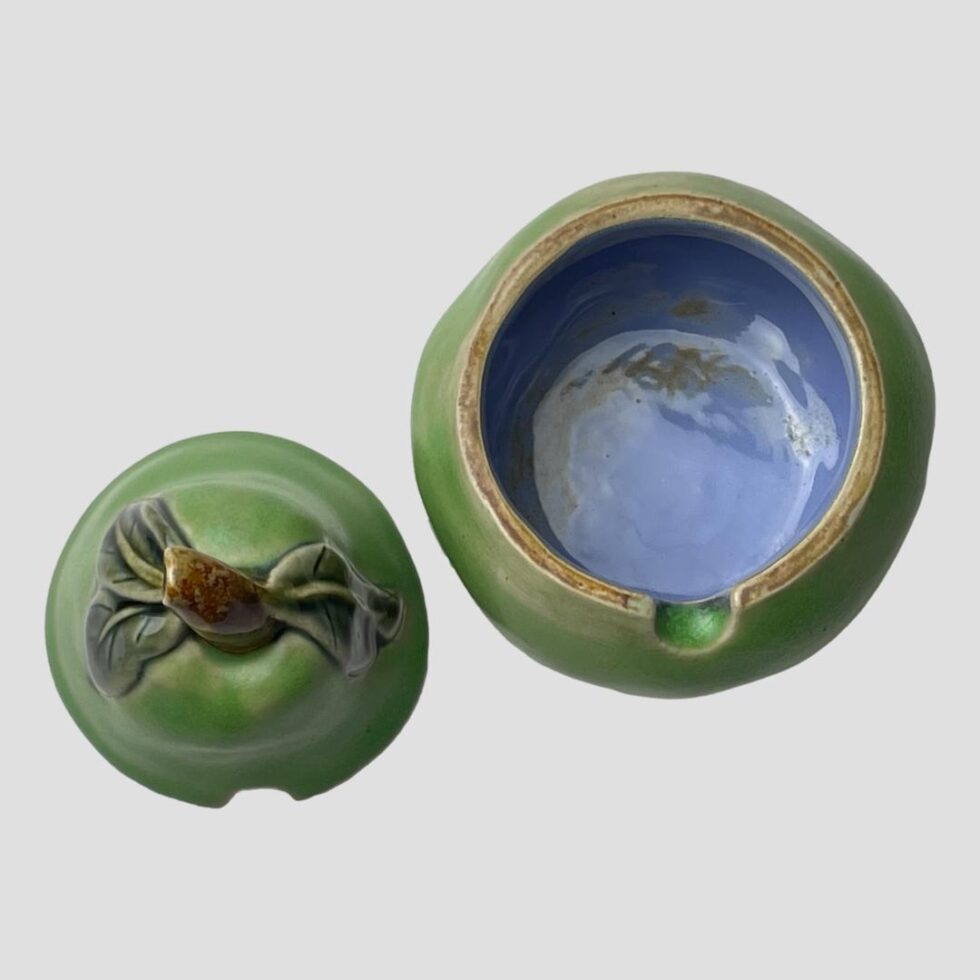 Photo of the pear preserve pot shown with lid removed and placed to the left of pot bottom. The inside of the pot has a lovely blue glaze.