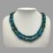 Main photo of vintage 2 strand turquoise neclklace displayed on a white display stand against a mid grey background. The beads are neatly in their 2 rows - shorter inside, longer outside and forward facing.