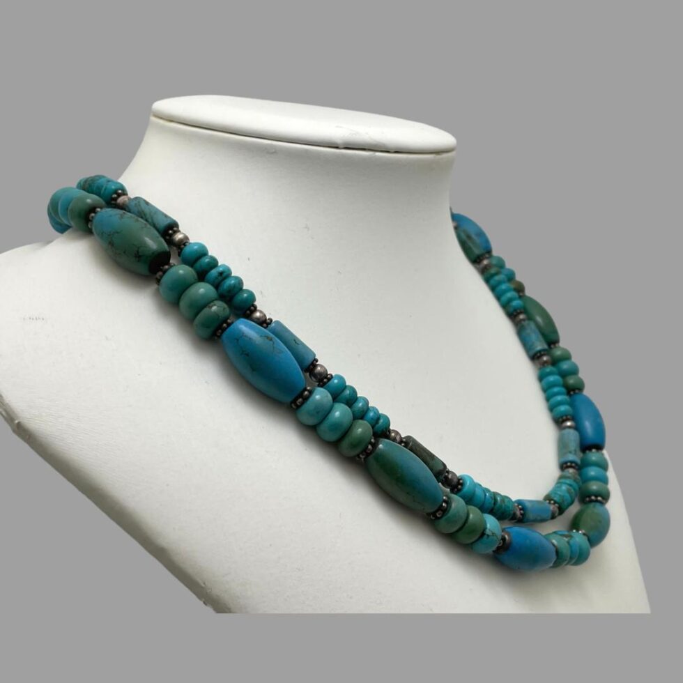 Photo of 2 strand turquoise necklace still on a display stand with the necklace front now facing towards the right.